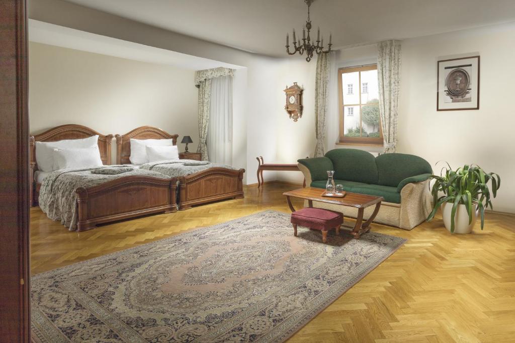 sypialnia z łóżkiem, kanapą i stołem w obiekcie Boutique Hotel Constans w Pradze