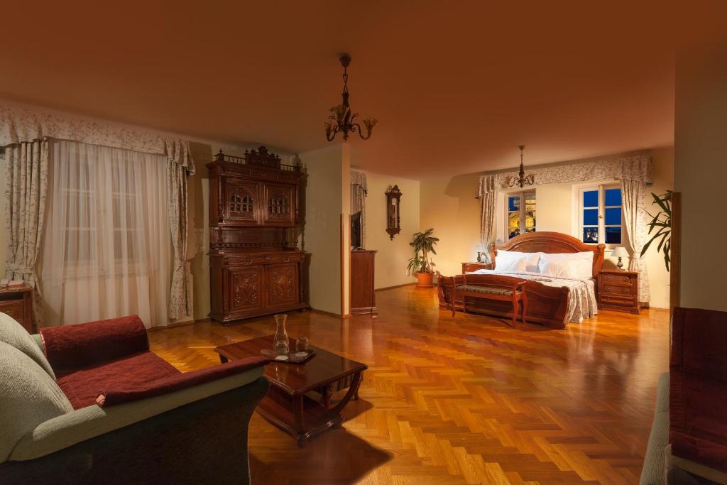 een woonkamer met een bed en een bank bij Boutique Hotel Constans in Praag