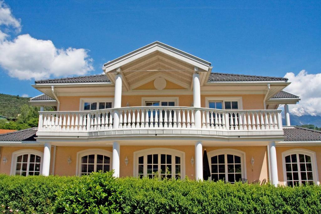 ein großes gelbes Haus mit einem weißen Balkon in der Unterkunft Villa Wellness Homes in Mötz