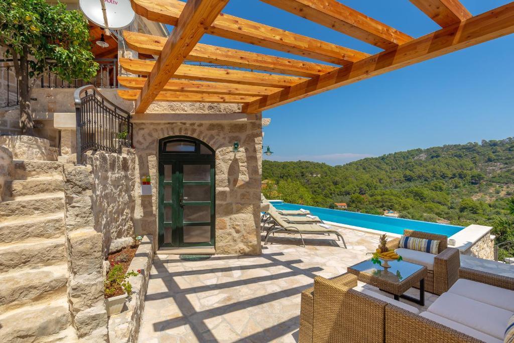 un patio con una pérgola de madera y una piscina en Villa Klacina en Goveđari