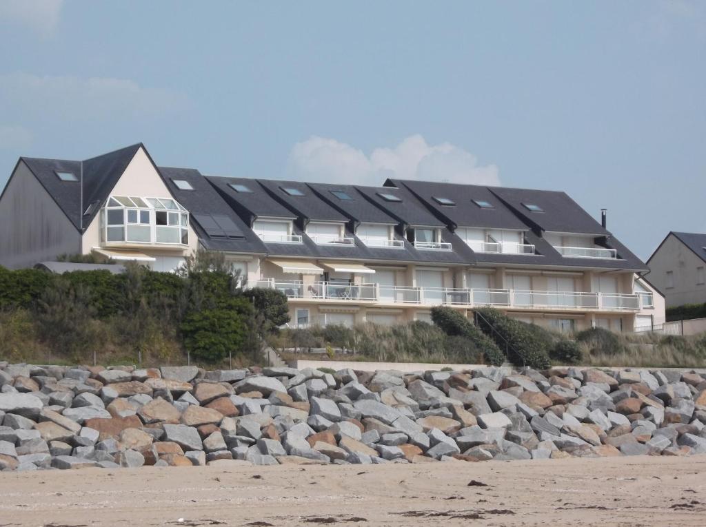 a building with solar panels on top of a pile of rocks at résidence les oyats in Jullouville-les-Pins