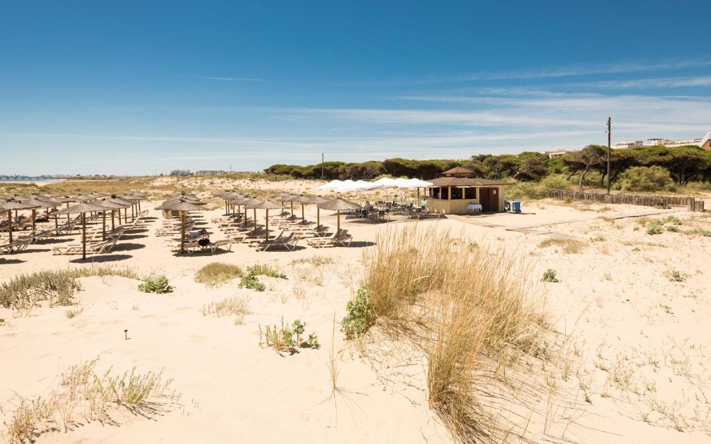 a beach with a lot of chairs in the sand at TUI Blue Isla Cristina Palace - Adults Recommended in Isla Cristina