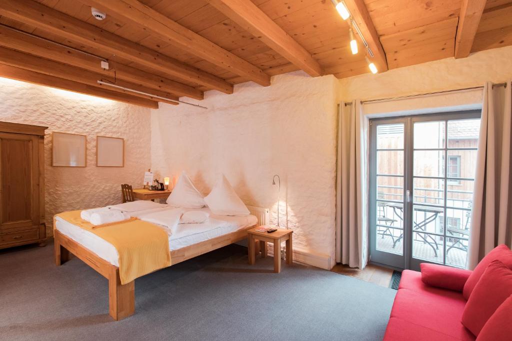 um quarto com uma cama e um sofá vermelho em Bio Hotel Kunstquartier em Nurembergue