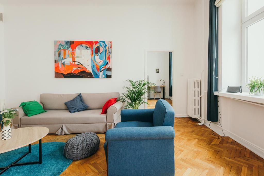 ワルシャワにあるoompH Warsaw Central Elegant Apartmentのリビングルーム(ソファ、青い椅子付)