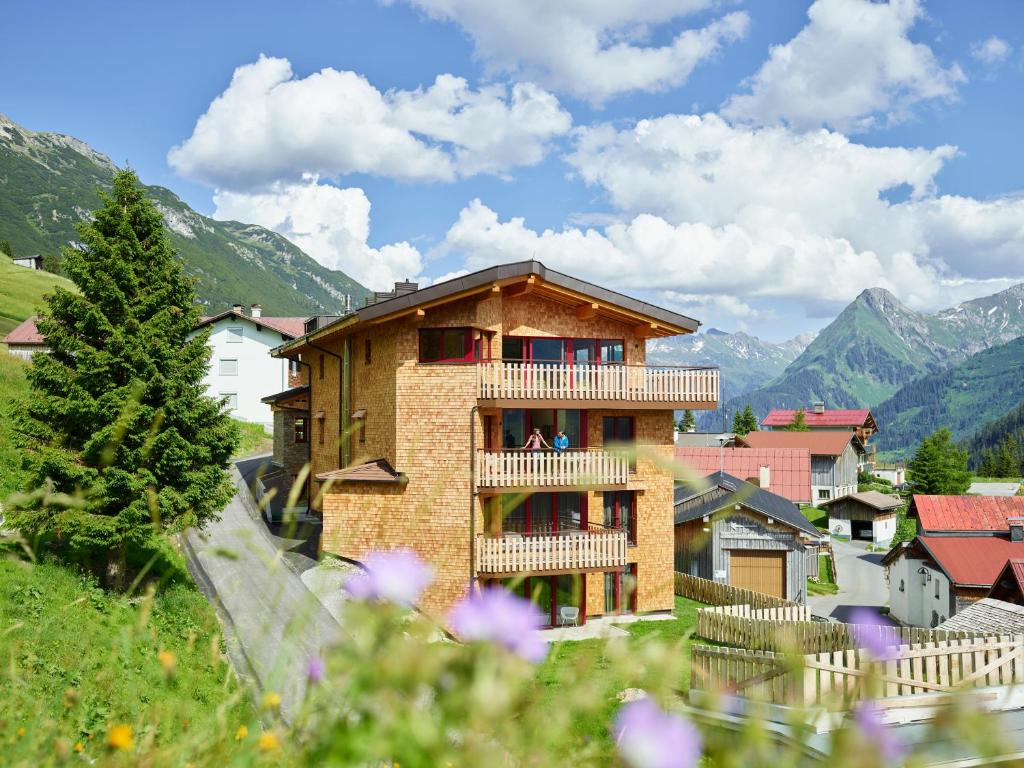 a building with a balcony and mountains in the background at Residenz Tirol in Lechleiten