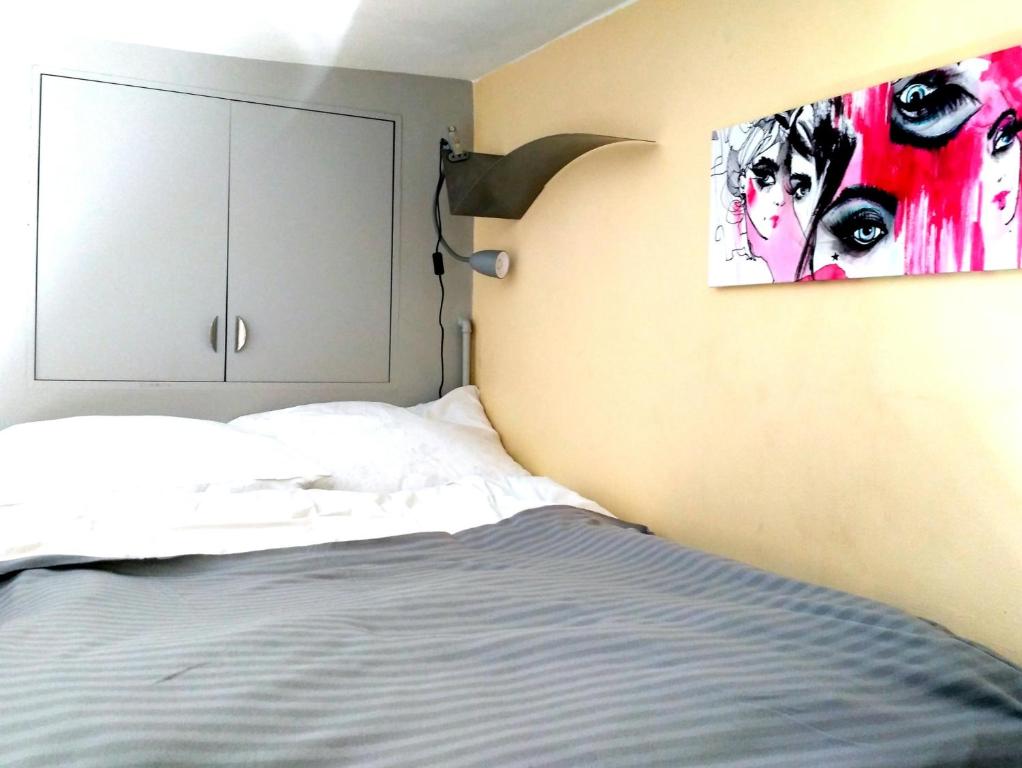 a bedroom with a bed and a painting on the wall at Studio Estery in Krakow