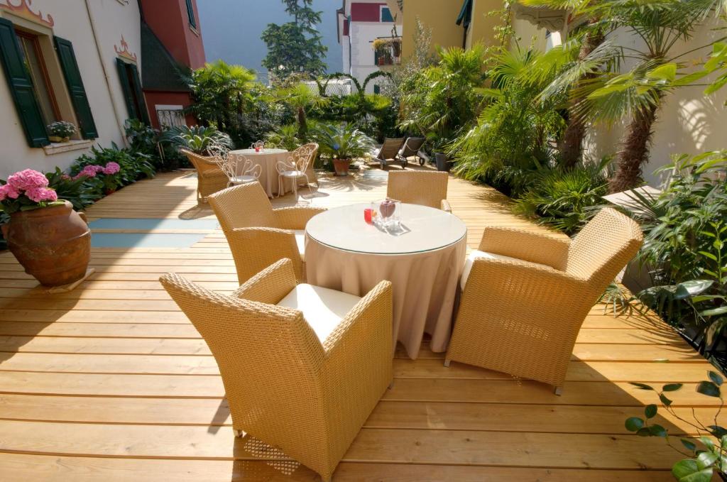 un patio con mesa, sillas y plantas en Sembenini Palace, en Riva del Garda