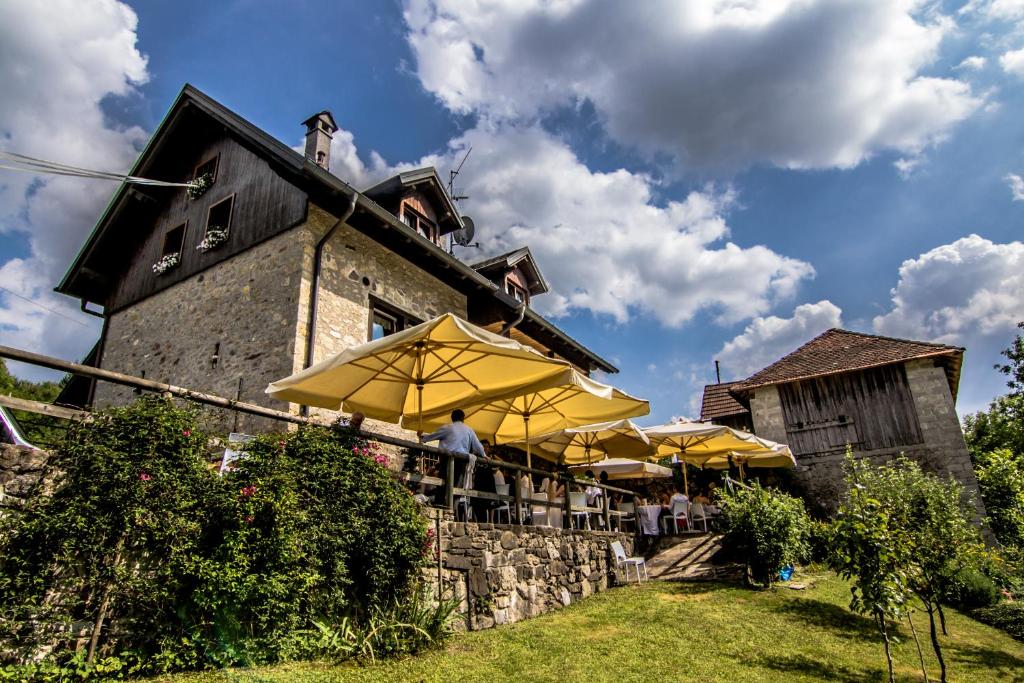 ein Restaurant mit gelben Sonnenschirmen vor einem Gebäude in der Unterkunft Villa Genziana in Ovaro