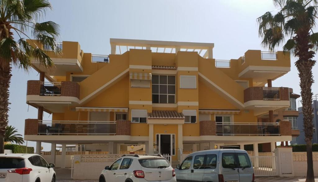 ein gelbes Gebäude mit davor geparkt in der Unterkunft Xeraco Beach in Xeraco