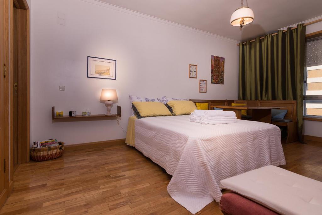1 dormitorio con cama blanca y mesa en Apartment in Portela near the Airport, en Lisboa