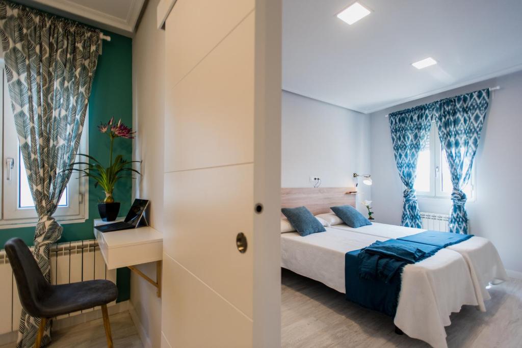 um quarto com uma cama, uma secretária e uma cadeira em Apartamentos River Santander em Santander