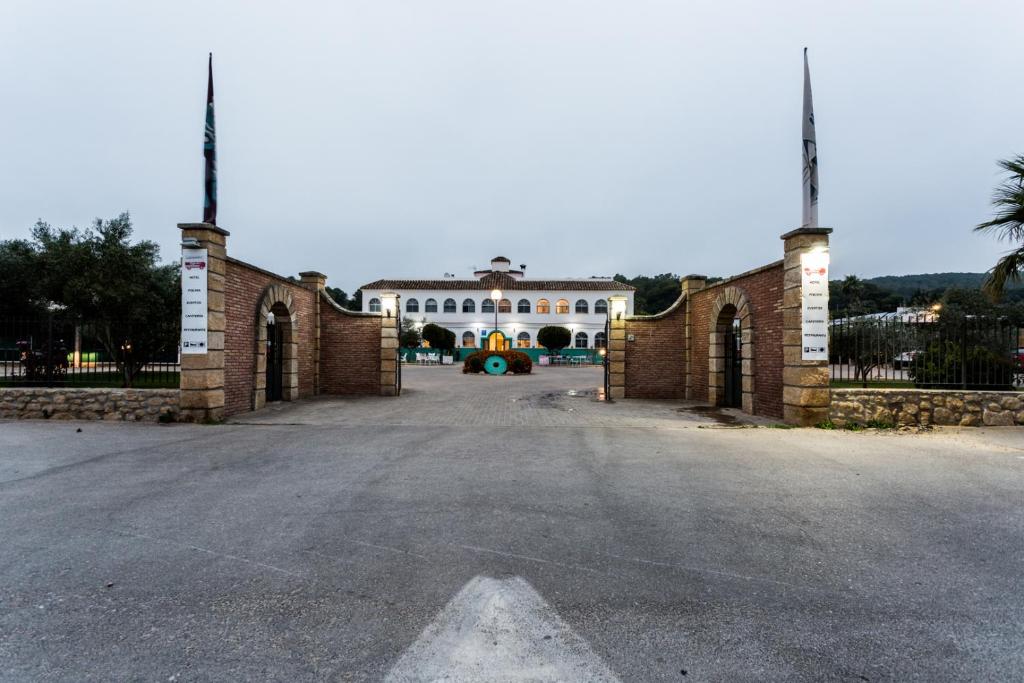 an open gate to a large white house at Hotel Nómadas in Vejer de la Frontera