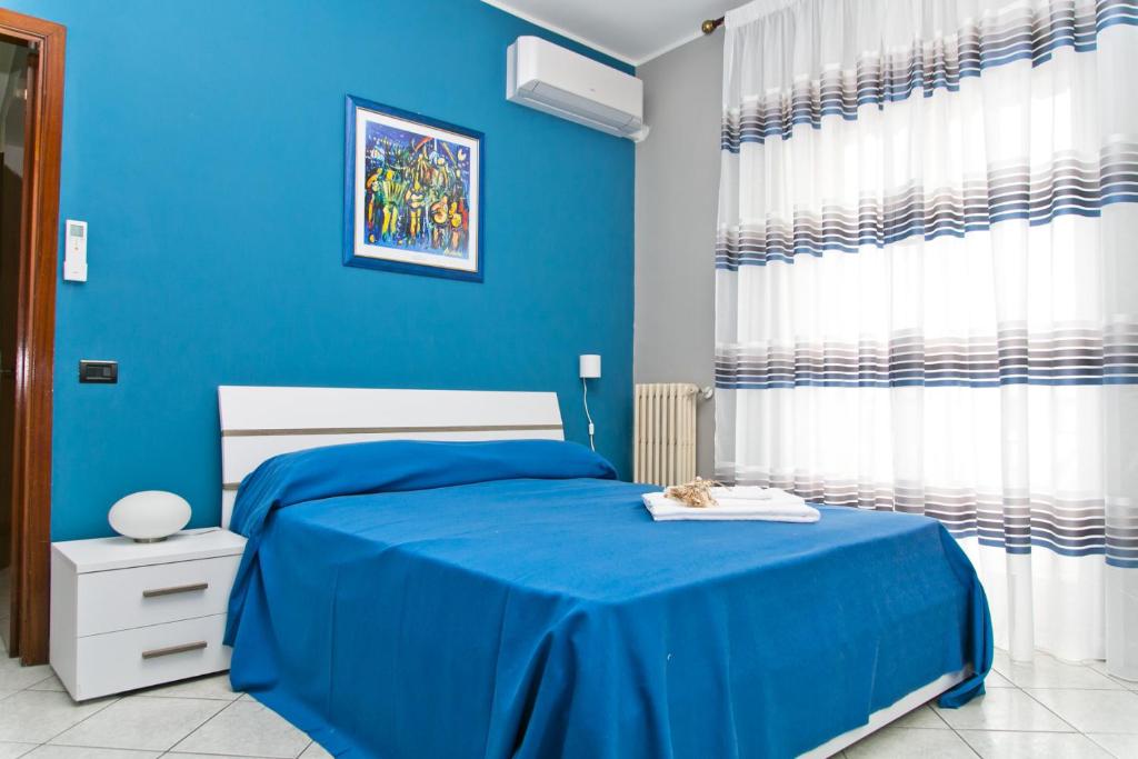 una camera blu con un letto e una parete blu di Bluemarine Apartment a Gallipoli