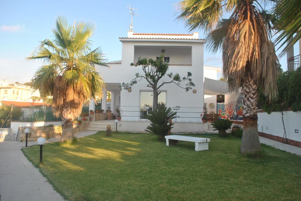 バレストラーテにあるVilla Anna Mariaの椰子の木とベンチのある白い家
