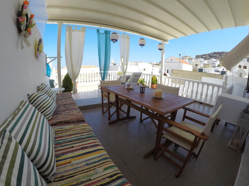 a balcony with a wooden table and chairs at Eleni Boutique Apartment in Lindos