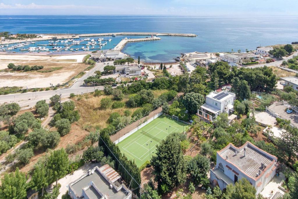 ポリニャーノ・ア・マーレにあるAmoredimare B&B in Villaのテニスコートと海の空中を望む