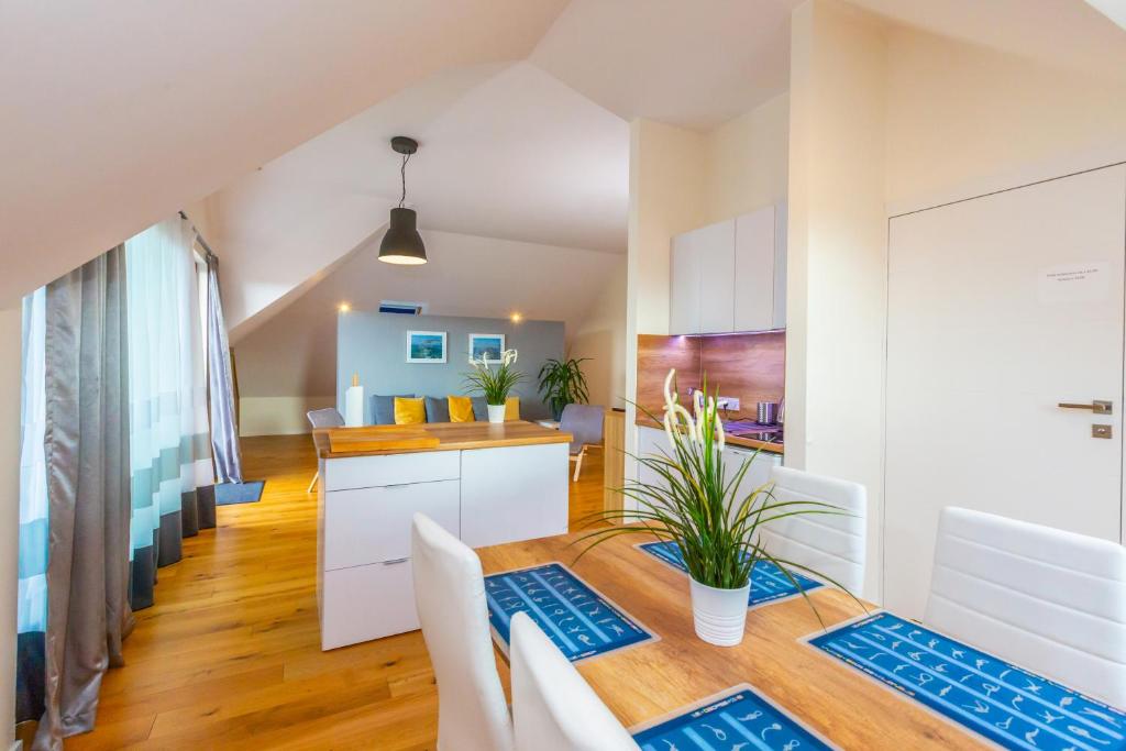una cucina e una sala da pranzo con tavolo in legno e tappetini blu di Apartament nad Zatoką a Władysławowo