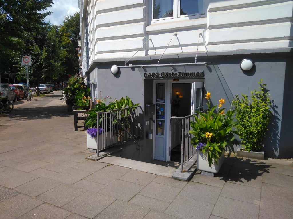 a front door of a shop with flowers in front of it at DARZ GästeZimmer in Hamburg