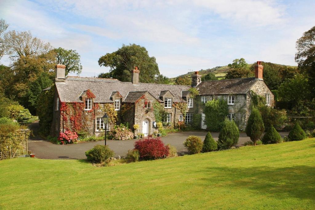 an estate in the hills with a green lawn at Collaven Manor in Okehampton