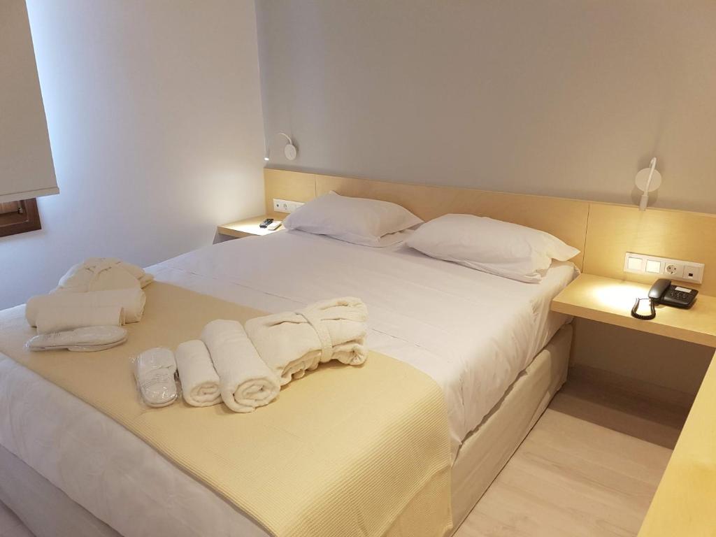 ein Hotelzimmer mit einem Bett mit Handtüchern darauf in der Unterkunft 8kto in Skiathos-Stadt