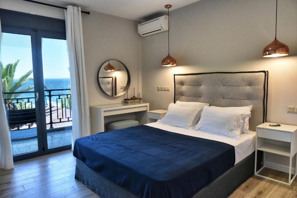a bedroom with a bed and a view of the ocean at Cos Seafront Apartments in Gerakini
