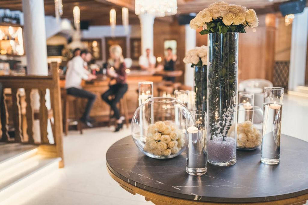 a table with vases and flowers on top of it at Schlosshotel Ischgl 5-Sterne Superior in Ischgl