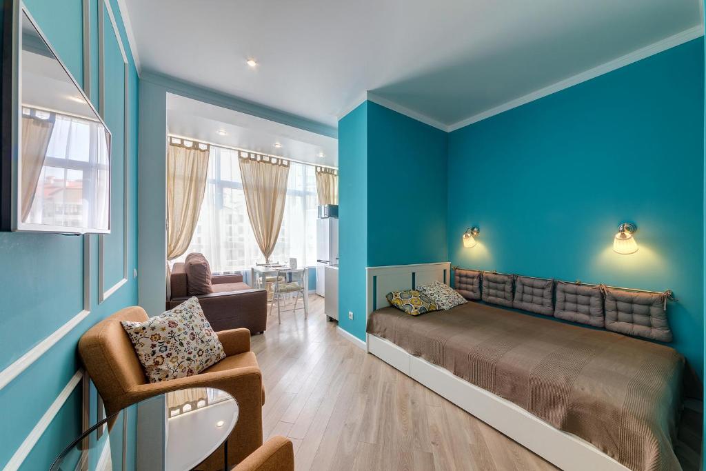 ゲレンジークにあるКвартиры-студии в Геленджикеの青い壁のベッドルーム1室、ベッド1台、椅子1脚が備わります。