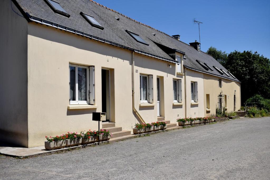 una fila de casas blancas con ventanas y flores en Chambres d'hôtes " Moulin du Couedic ", en Nivillac