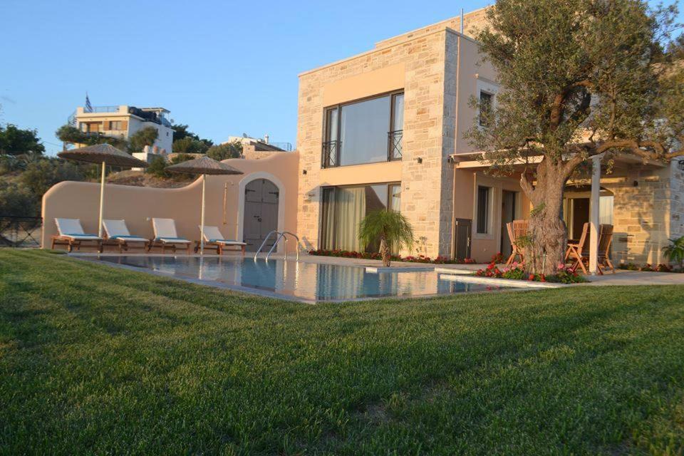 a house with a swimming pool in front of a yard at Villa Salla in Sívas