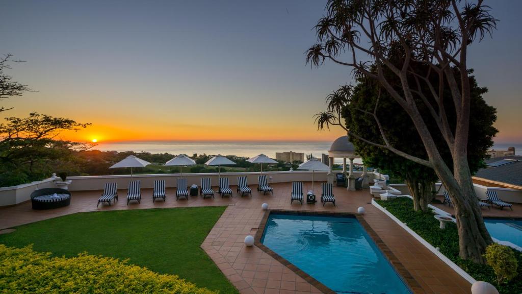 a view of the pool at a resort with the sunset at The View Boutique Hotel & Spa in Amanzimtoti
