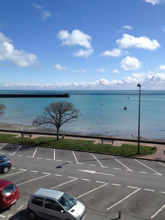 un parking avec des voitures garées au bord de l'océan dans l'établissement Le Querrien, à Cancale