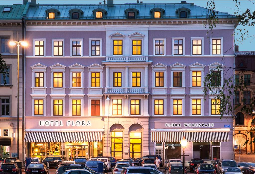 un grand bâtiment avec des voitures garées devant lui dans l'établissement Hotel Flora, à Göteborg