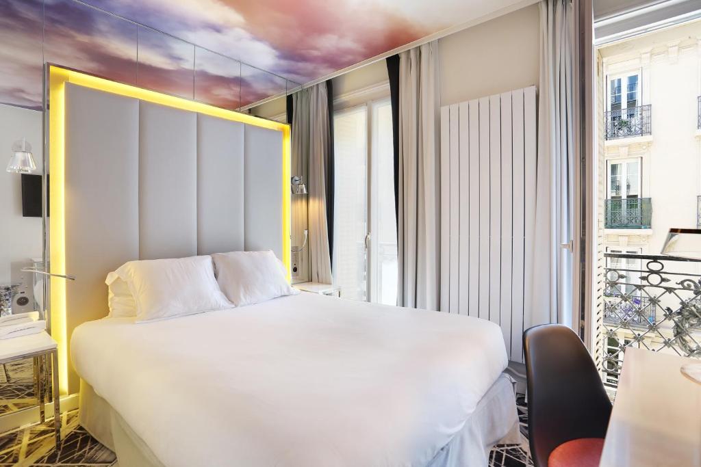 パリにあるヌヴェル ホテル エッフェルのベッドルーム(大きな白いベッド1台、窓付)