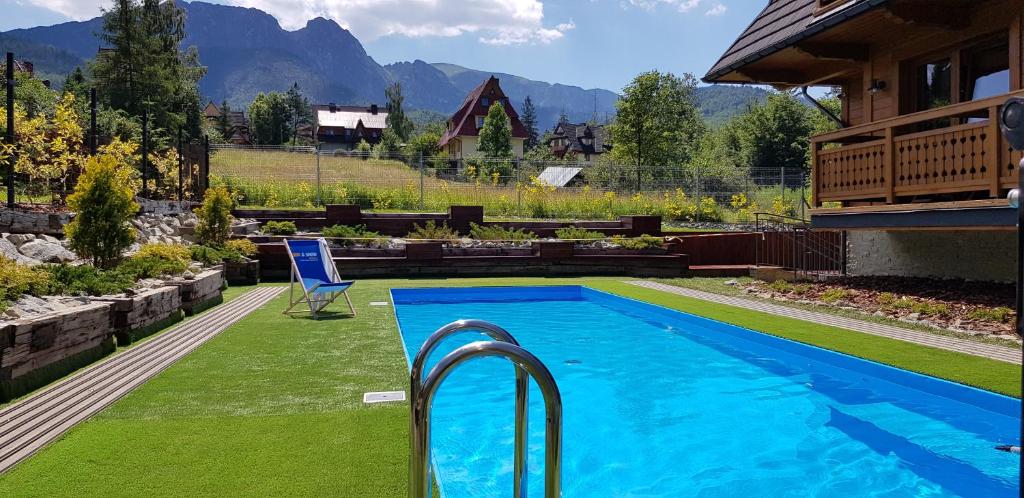a swimming pool in the yard of a house at Apartamenty Sun & Snow Lipki Park Zakopane in Zakopane