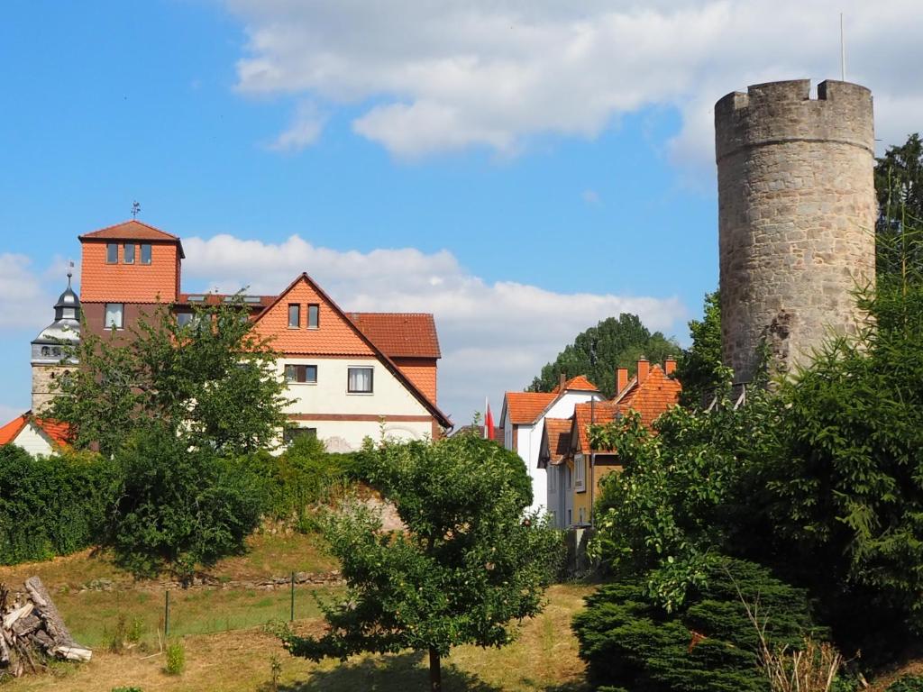 a house with two towers on a hill with trees at Frau Holle-Land-Hotel ehem Burghotel Witzenhausen in Witzenhausen