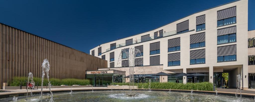 a building with a fountain in front of a building at Hotel Melchior Park in Würzburg