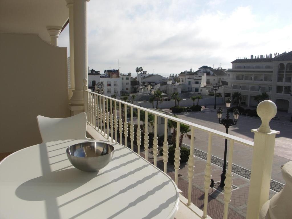 a bowl on a table on a balcony with a view at Apartamentos Plaza España in Nerja