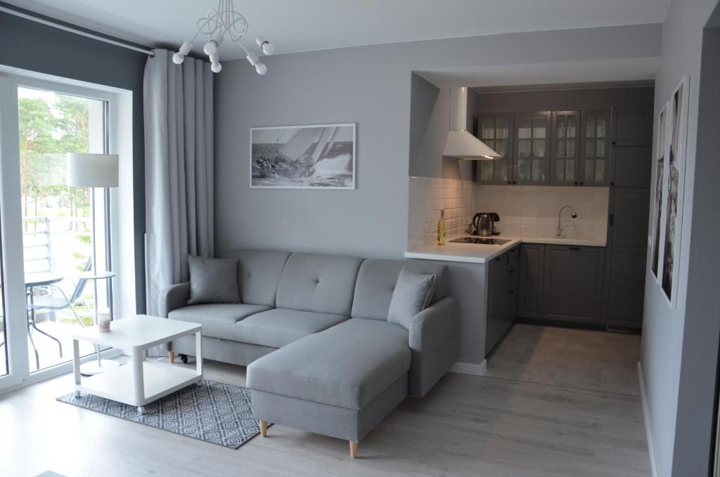 a living room with a couch and a table at Apartament 45 Baltic Park Pogorzelica in Pogorzelica