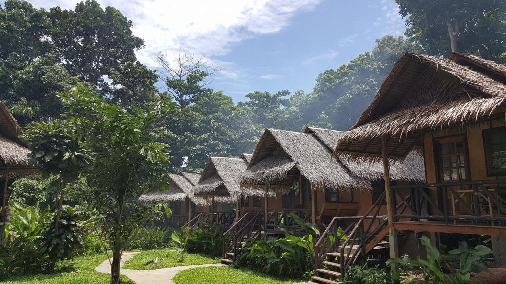 a row of houses with thatched roofs at Jungle Garden in Ko Chang