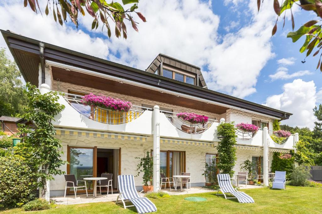 ein Haus mit Stühlen und Blumen im Hof in der Unterkunft Gästehaus Anita in Gailingen