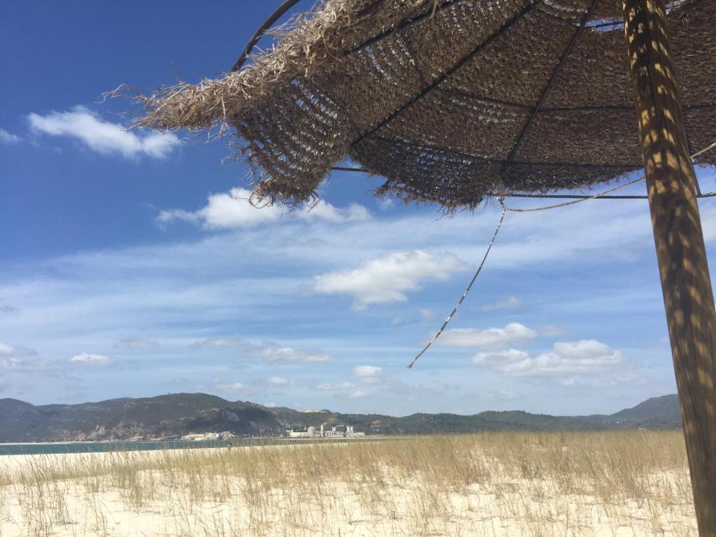 トロイアにあるTróia Férias na Praiaの藁傘と海のビーチ