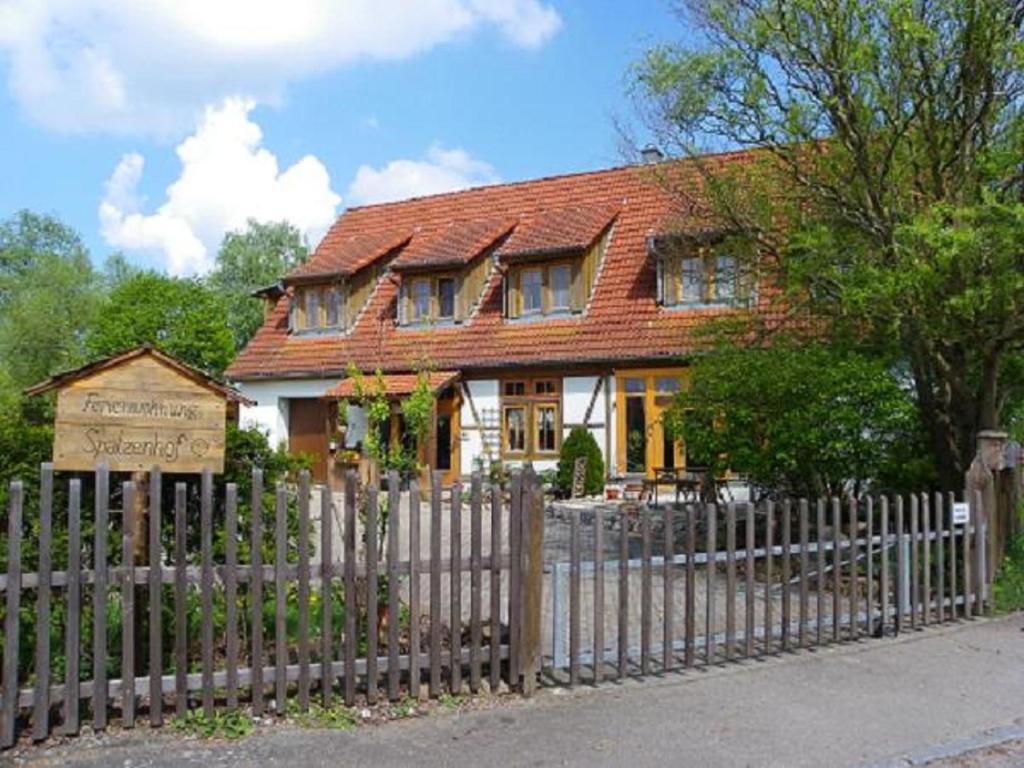 una casa con una valla de madera delante de ella en Spatzenhof, en Weiltingen