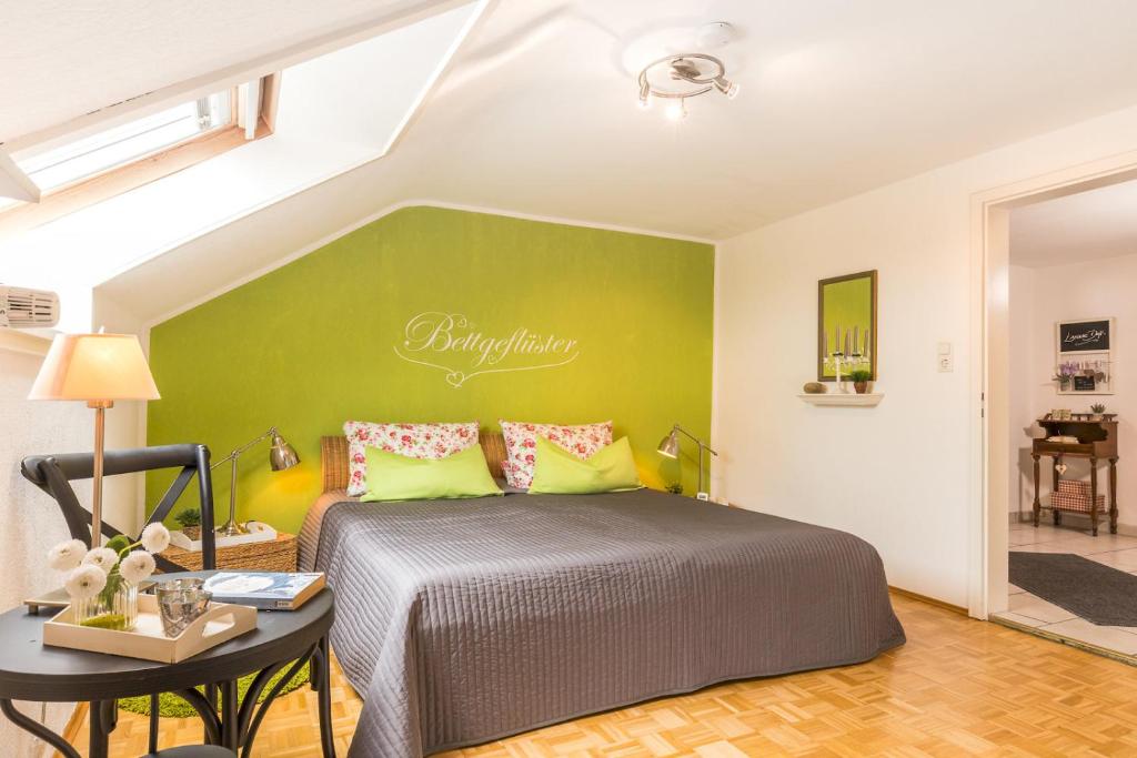 Un dormitorio con una cama y una pared verde. en Ferienwohnung Auszeit, en Markdorf