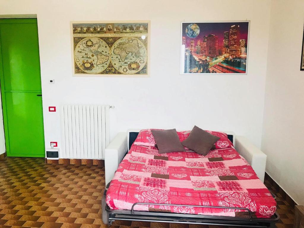 サンタンブロージョ・ディ・ヴァルポリチェッラにあるCris Apartmentsのベッドルーム1室(ベッド1台付)が備わります。壁に2枚の写真が飾られています。