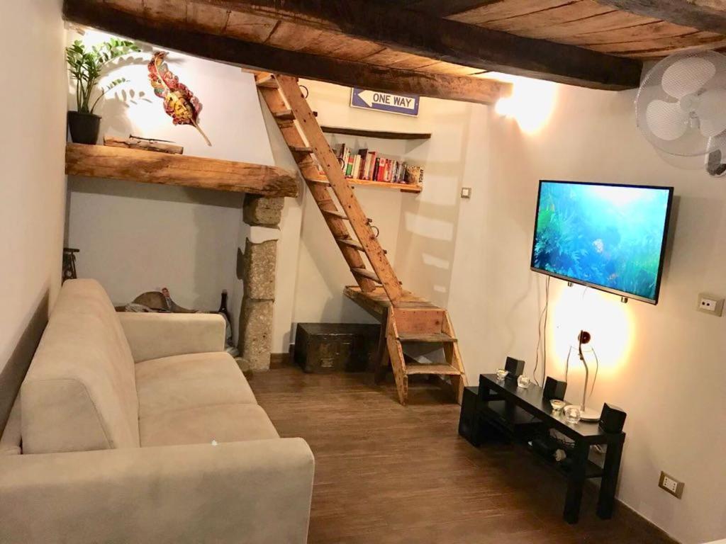 ein Wohnzimmer mit einem weißen Sofa und einem TV in der Unterkunft Casa SoleLuna in Calcata