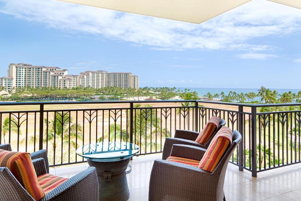 Un balcón con sillas y vistas al océano. en Sixth Floor Villa with Sunrise View - Beach Tower at Ko Olina Beach Villas Resort en Kapolei