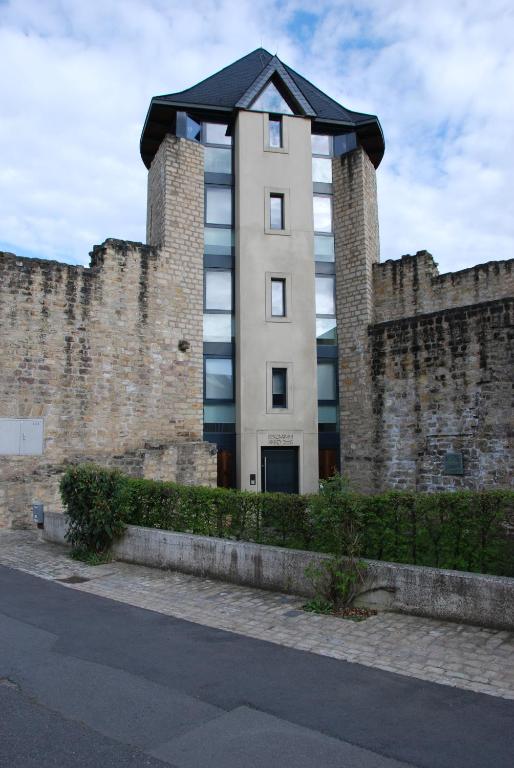 un edificio alto detrás de una pared de ladrillo en Wollefstuerm, en Echternach
