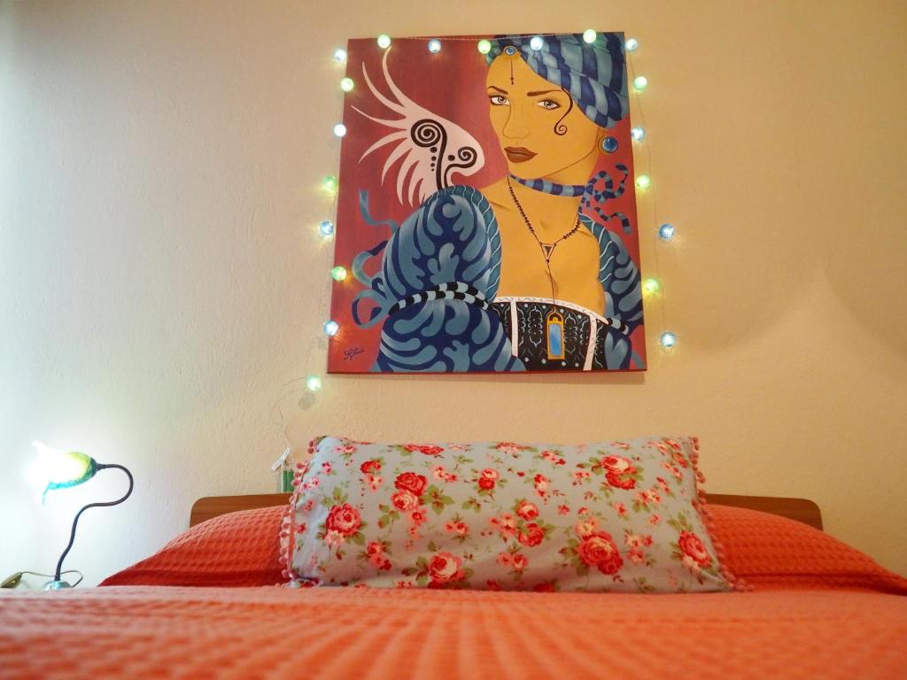 uma pintura na parede acima de uma cama com uma almofada em Sunny apartment near the center em Tessalônica
