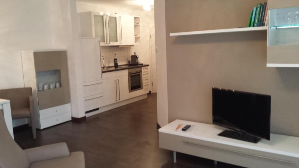 uma sala de estar com televisão e uma cozinha em Wellness- & Golf-Appartement 4.4 Hebelhof em Bad Bellingen