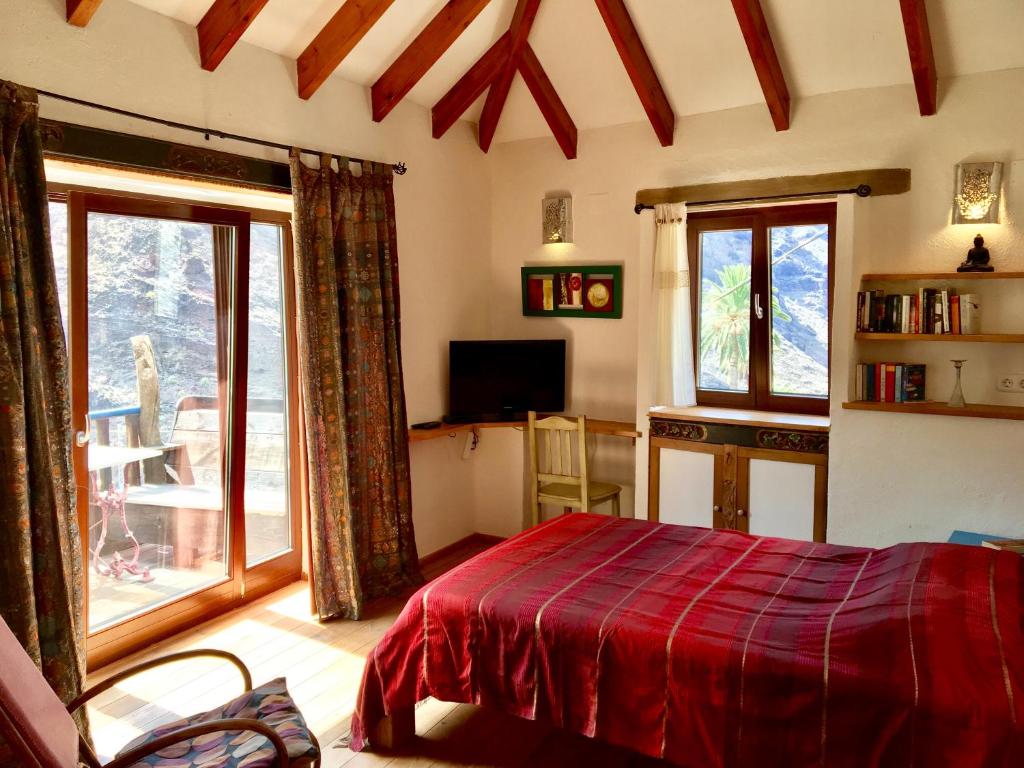 una camera con un letto con una coperta rossa di Casa Bonita a Valle Gran Rey